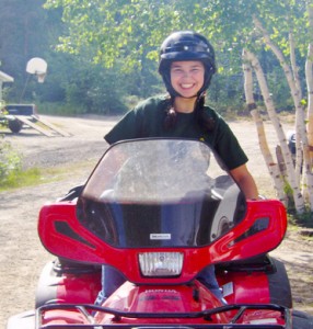 Cindy riding an ATV at Camp Munroe